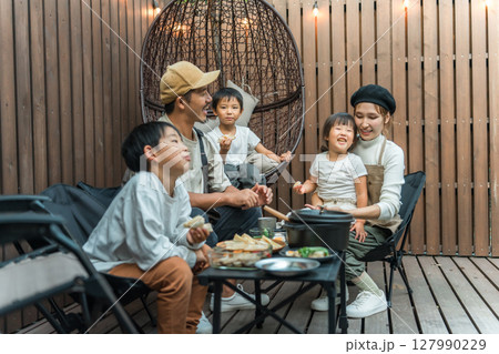 ウッドデッキで食事するファミリー(グランピング,アウトドア,別荘,コテージ) ウッドデッキで食事するファミリー(グランピング,アウトドア,別荘,コテージ) 127990229
