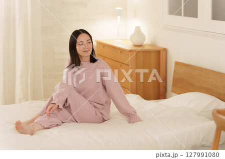夜ベッドでストレッチする女性 127991080