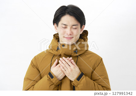 ダウンジャケットを着た男性　安心する　白背景 127991342