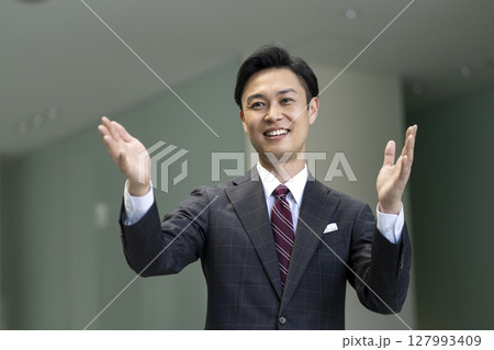 身振りを交えて話すスーツを着た40代の男性 身振りを交えて話すスーツを着た40代の男性 127993409