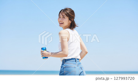 青空の下で楽しむ夏の爽やか飲み物と笑顔の女性ポートレート 青空の下で楽しむ夏の爽やか飲み物と笑顔の女性ポートレート 127993720