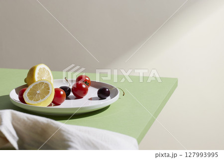 A cozy backdrop with fresh fruits and grass on a table with natural sunlight and shadows. A cozy backdrop with fresh fruits and grass on a table with natural sunlight and shadows. 127993995