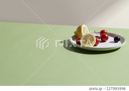 A cozy backdrop with fresh fruits and grass on a table with natural sunlight and shadows. A cozy backdrop with fresh fruits and grass on a table with natural sunlight and shadows. 127993996