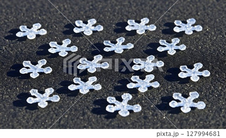Sparkling Snowflake Confetti on Textured Dark Surface in Bright 127994681