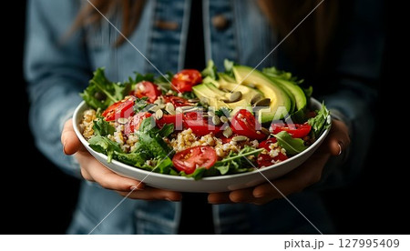 Healthy salad bowl with avocado and tomatoes food photography 127995409