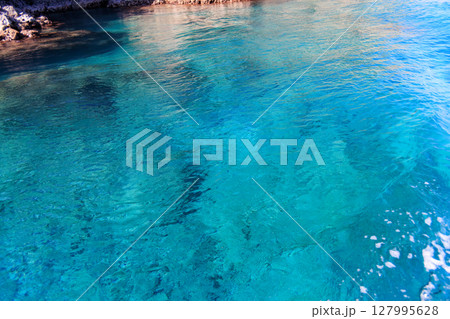 ヒリゾ浜渡船に乗って出港するスキンダイバー、シュノーケラー。 青い海と無人島の大根島、岩礁が見える。 ヒリゾ浜渡船に乗って出港するスキンダイバー、シュノーケラー。 青い海と無人島の大根島、岩礁が見える。 127995628