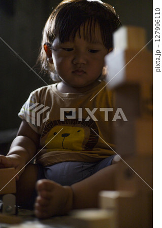 Toddler Playing With Wooden Toys, Background for advertising and wallpaper in education and lifestyle scene. Toddler Playing With Wooden Toys, Background for advertising and wallpaper in education and lifestyle scene. 127996110