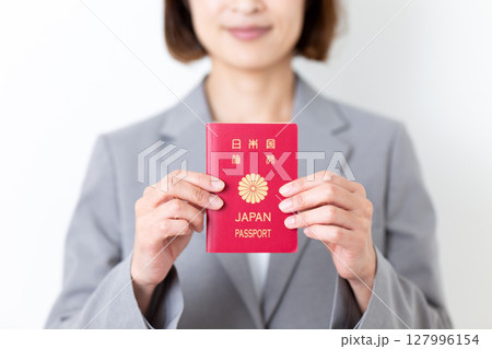 パスポートを持つグレーのスーツ姿のミドル女性 パスポートを持つグレーのスーツ姿のミドル女性 127996154
