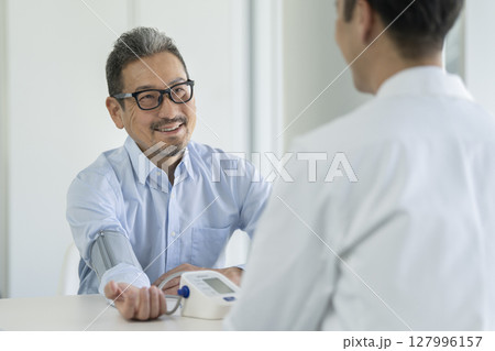 血圧測定を受けるシニア男性 127996157