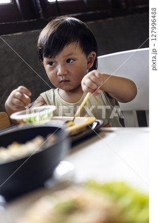 Toddler Is Eating Breakfast By Himself, Background for advertising and wallpaper in food and drink lifestyle scene. Toddler Is Eating Breakfast By Himself, Background for advertising and wallpaper in food and drink lifestyle scene. 127996488