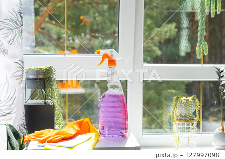 Window cleaning products are lying on the windowsill with a rag, spray, detergent. Spring cleaning in the house, cleaning service 127997098