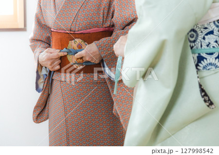 帯締めを直す手元 127998542