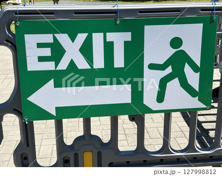 Exit sign on the plastic security rail 127998812