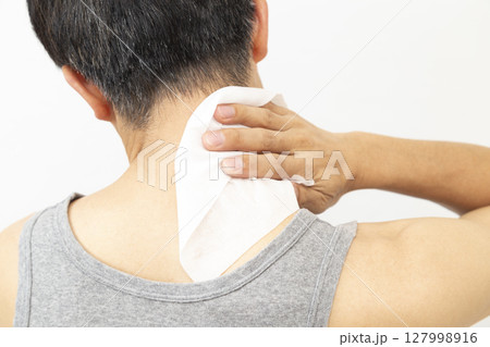 汗拭きシートで体を拭く男性　白バック 127998916