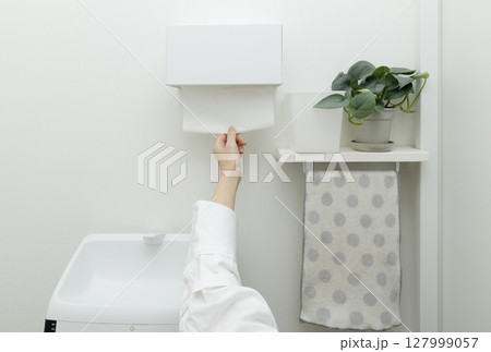 トイレでペーパータオルを使う女性の手 トイレでペーパータオルを使う女性の手 127999057