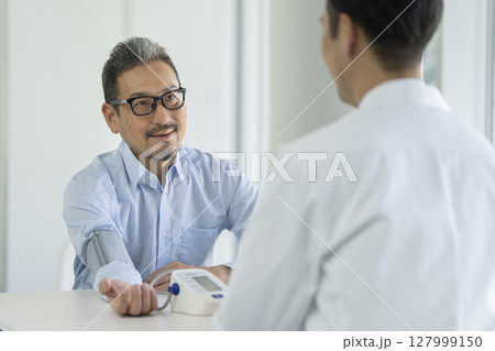 血圧測定を受けるシニア男性 127999150