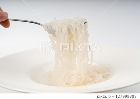 Shirataki or konnyaku pasta in white plate on fork close up. Konjak jelly noodles 127999885