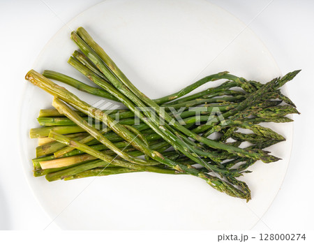 Cooked asparagus isolated. Roasted green vegetable for salad, baked asparagus bunch 128000274