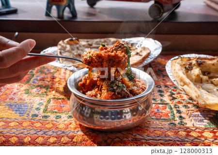 Lamb curry with tomatoes and fiery chili, traditional Indian Laal Maas served in a metal dish 128000313