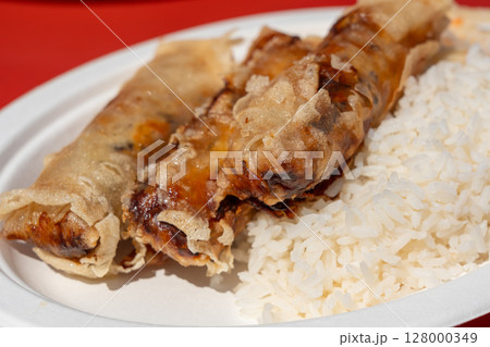 Fried spring rolls. Crispy springrolls, roasted egg rolls with boiled rice and cabbage salad Fried spring rolls. Crispy springrolls, roasted egg rolls with boiled rice and cabbage salad 128000349