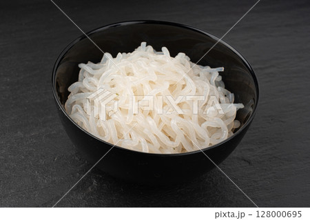 Shirataki or konnyaku pasta in black bowl. Konjak jelly noodles, Japanese zero calorie sirataki Shirataki or konnyaku pasta in black bowl. Konjak jelly noodles, Japanese zero calorie sirataki 128000695