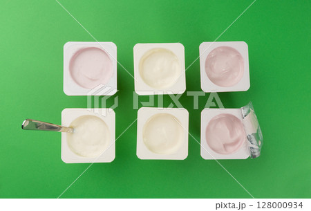 Yogurt cups set, pink and yellow fruit yoghurt in plastic pots, milk pudding container with spoon 128000934
