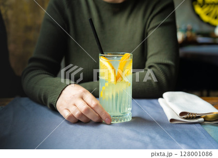 Ice lemonade in tall glass. Yuzu mocktail with lemon and soda, cool lime juice cocktail Ice lemonade in tall glass. Yuzu mocktail with lemon and soda, cool lime juice cocktail 128001086