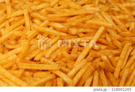 Fried chips sticks texture background, finger potato ketchup flavored chips pattern, shoestring fries Fried chips sticks texture background, finger potato ketchup flavored chips pattern, shoestring fries 128001205