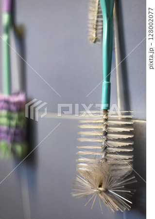 Baby bottle wash tool hanging on the wall in bathroom 128002077