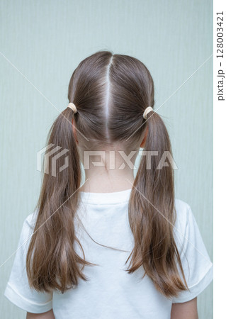 Rear view of little girl in floral dress looking at wall. Isolated on white background Rear view of little girl in floral dress looking at wall. Isolated on white background 128003421