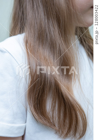 Young woman with long, dark blonde hair pulled back in a low ponytail. Casual hairstyle. Sporty hairstyle. Running hairstyle. 128003422