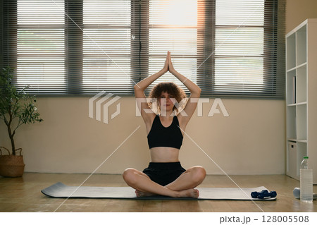Calm female yogi in sportswear focusing on mindfulness and breathing during a meditation session Calm female yogi in sportswear focusing on mindfulness and breathing during a meditation session 128005508
