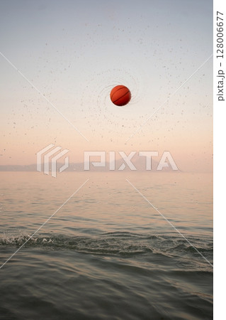 Family enjoys sunset at the beach playing with a vibrant basketball Family enjoys sunset at the beach playing with a vibrant basketball 128006677