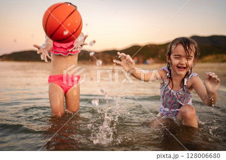 Family fun at the beach with kids splashing in the water Family fun at the beach with kids splashing in the water 128006680