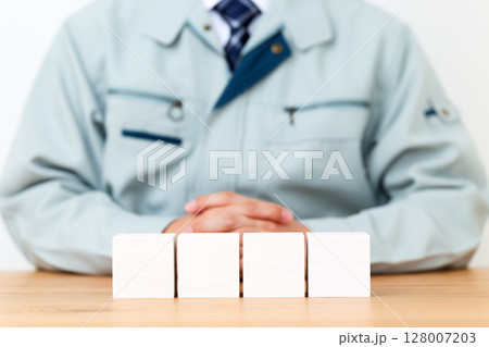 作業着を着たミドル男性ビジネスマンとブロック 128007203