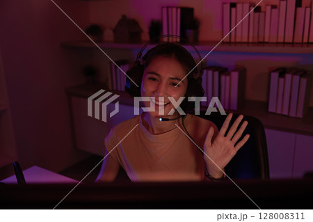 Friendly Gamer Waving During Live Stream Session Friendly Gamer Waving During Live Stream Session 128008311