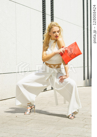 Fashion woman white outfit with red handbag 128008424