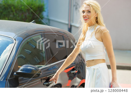 Fashionable woman opening car Fashionable woman opening car 128008448