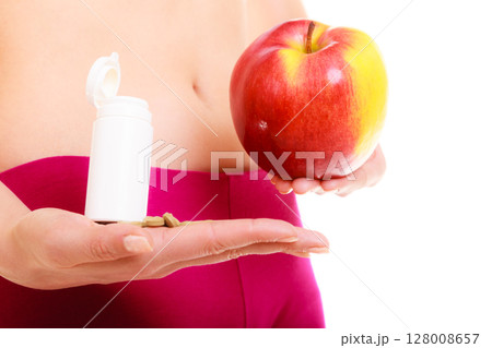 Woman holding vitamins and apple. Health care. Woman holding vitamins and apple. Health care. 128008657