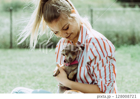 Woman playing with little dog outside Woman playing with little dog outside 128008721