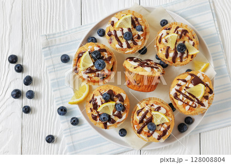 tasty blueberry muffins with lemon chocolate glaze 128008804