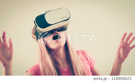 Girl wearing virtual reality goggles. 128008823