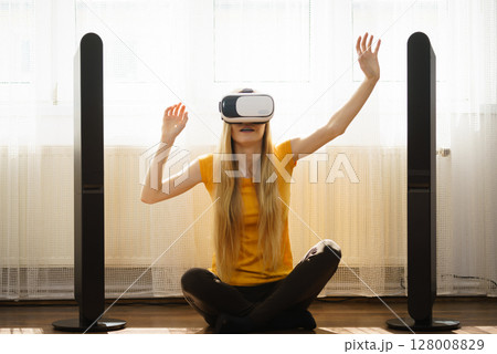 Girl wearing virtual reality goggles at home Girl wearing virtual reality goggles at home 128008829