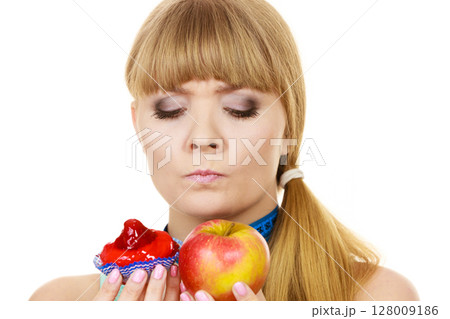 Woman choosing fruit or cake make dietary choice Woman choosing fruit or cake make dietary choice 128009186