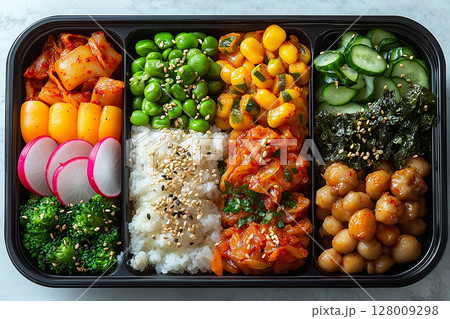 Korean-style lunch box with bibimbap ingredients, kimchi and pickled radish. Container with dosirak. Korean-style lunch box with bibimbap ingredients, kimchi and pickled radish. Container with dosirak. 128009298