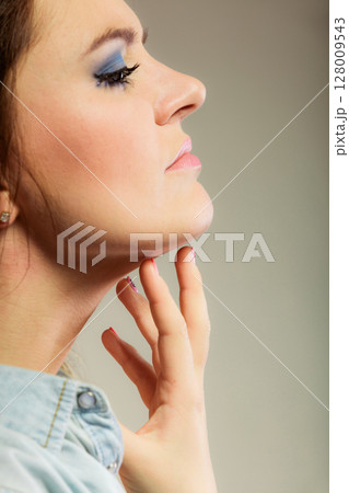 Woman scratching her neck Woman scratching her neck 128009543
