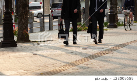 午後の都市の街で歩くサラリーマンの姿 午後の都市の街で歩くサラリーマンの姿 128009589