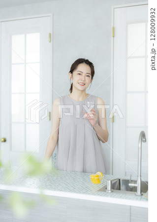 キッチンで水を飲む女性 128009932