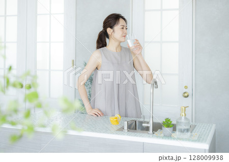 キッチンで水を飲む女性 128009938