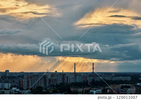 Dramatic Sunset Over City Skyline With Industrial Chimneys Dramatic Sunset Over City Skyline With Industrial Chimneys 128011087